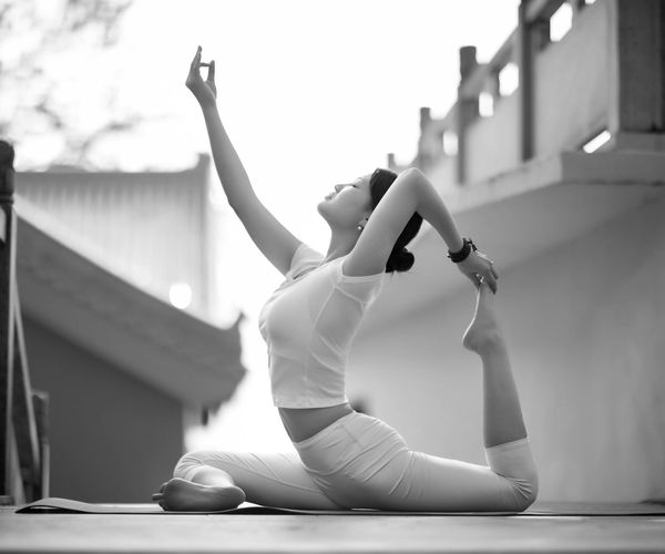 Detailed view of a flexible yoga practitioner in a dark room.